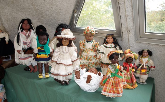 Présentation de poupées et poupons sur une table sur fond vert nous pourrions dire tous les enfants du monde.